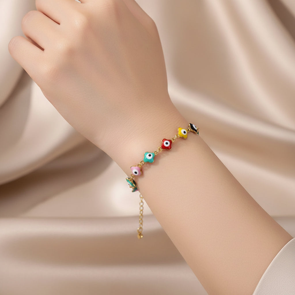 Gold bracelet with colorful eye-shaped beads on a beige fabric background