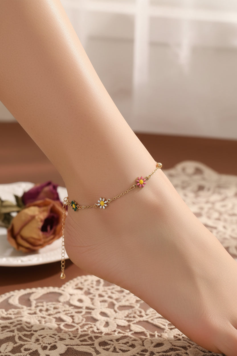 Gold bracelet with colorful flower charms on a brown surface